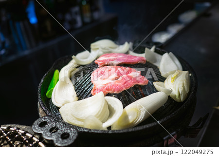 ラム肉を使ったバーベキュー料理のジンギスカン。鉄鍋でラム肉と野菜を焼いている。。 ラム肉を使ったバーベキュー料理のジンギスカン。鉄鍋でラム肉と野菜を焼いている。。 122049275
