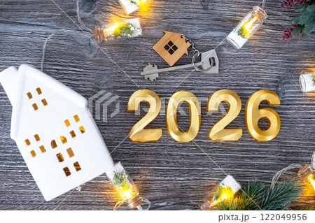 New Year 2026 golden numbers and House key with tiny form of home on festive grey wooden background flatlay, lights of garlands, greeting card. Housing, real estate, relocation, mortgage, insurance New Year 2026 golden numbers and House key with tiny form of home on festive grey wooden background flatlay, lights of garlands, greeting card. Housing, real estate, relocation, mortgage, insurance 122049956