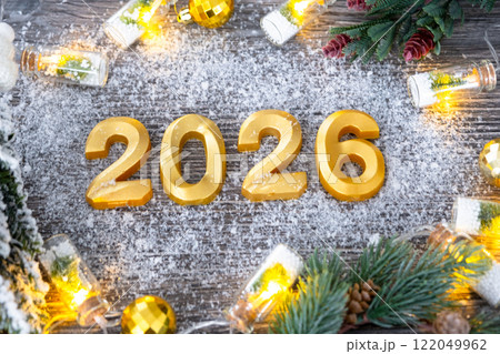 Happy New Year golden numbers 2026 on cozy festive grey wooden background with Christmas tree, snow, lights of garlands. Greetings, postcard. Calendar, cover 122049962