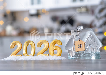 Golden number 2026, key and tiny home on background of cozy white kitchen with Christmas tree and Christmas decor with garland lights. Housing, interior, renovation, mortgage, rent in New Year Golden number 2026, key and tiny home on background of cozy white kitchen with Christmas tree and Christmas decor with garland lights. Housing, interior, renovation, mortgage, rent in New Year 122050029