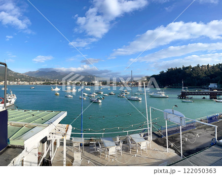 Azure sea and yachts in marina. Vacation spot and town in Liguria. Nature and meditation. Mountains and sun in summer. Azure sea and yachts in marina. Vacation spot and town in Liguria. Nature and meditation. Mountains and sun in summer. 122050363
