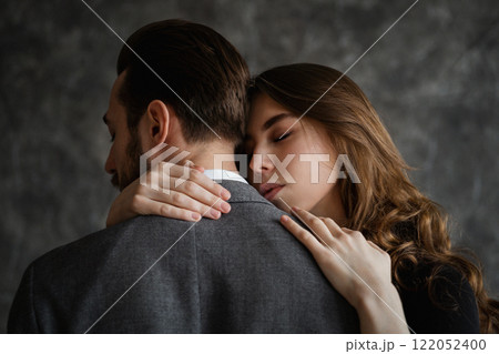 Tender embrace of lovers, a man stands with his back to the camera, women's hands are visible 122052400
