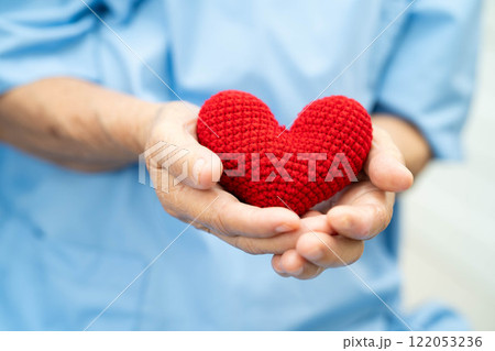 Asian elder senior woman patient holding red heart in hospital. 122053236