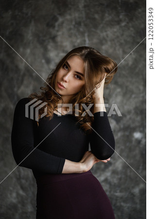 Expressive portrait of a young woman striking a confident pose in an artistic studio setting Expressive portrait of a young woman striking a confident pose in an artistic studio setting 122053349