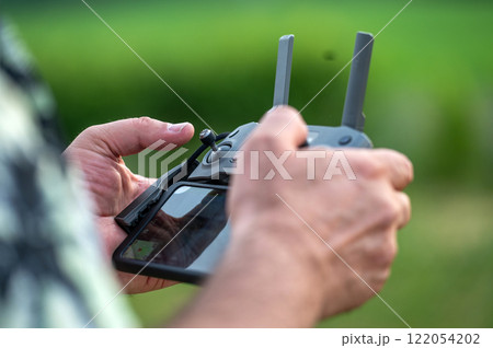 A man holding a remote control of a drone in his hand, close-up A man holding a remote control of a drone in his hand, close-up 122054202