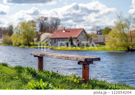 Wooden bench on the bank of the river. Spring landscape. Wooden bench on the bank of the river. Spring landscape. 122054204