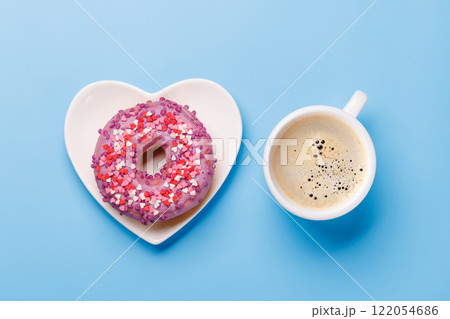 A vibrant donut on a heart-shaped saucer and a coffee cup, perfect for a Valentines Day card 122054686
