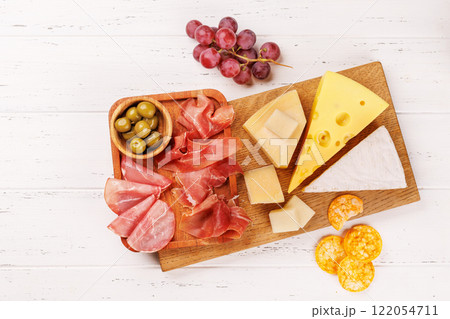 A delectable arrangement of various cheeses, fresh grapes, prosciutto 122054711
