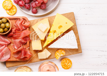 A delectable arrangement of various cheeses, fresh grapes, prosciutto and wine A delectable arrangement of various cheeses, fresh grapes, prosciutto and wine 122054715