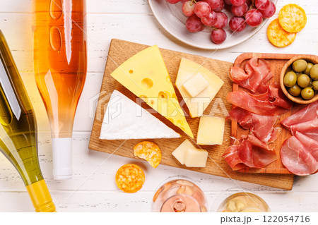 A delectable arrangement of various cheeses, fresh grapes, prosciutto and wine 122054716