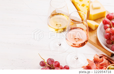 A delectable arrangement of various cheeses, fresh grapes, prosciutto and wine 122054718