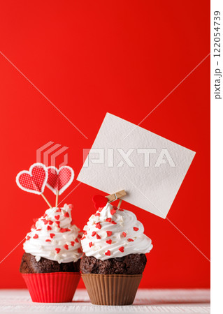 Cupcake love: Heart-themed treats on a vibrant red backdrop Cupcake love: Heart-themed treats on a vibrant red backdrop 122054739