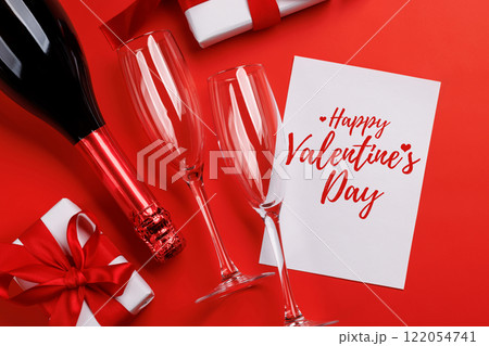 Champagne and gift: Celebratory duo on a red background with text space Champagne and gift: Celebratory duo on a red background with text space 122054741