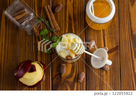 sweet homemade yogurt in a glass with apples, nuts and honey 122055922