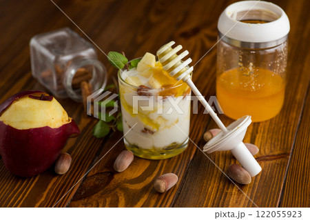 sweet homemade yogurt in a glass with apples, nuts and honey sweet homemade yogurt in a glass with apples, nuts and honey 122055923