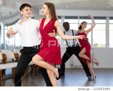Young man and girl dancing tango in couple during lesson at studio 122055995