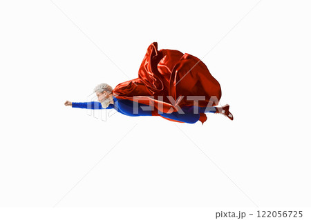 Gray-haired superhero in vibrant blue and red costume flies forward with cape billowing. Determination, fantasy and adventure 122056725