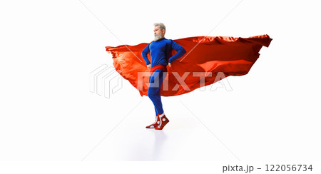 Confident and determined man with grey bear, in blue superhero costume and red cape flowing dramatically in the air, exuding courage 122056734