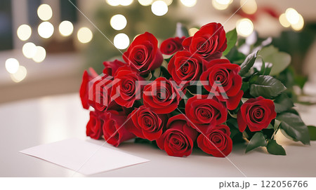 A beautiful bouquet of red roses with a handwritten Valentine Day card, displayed on a white table with elegant lighting. 122056766