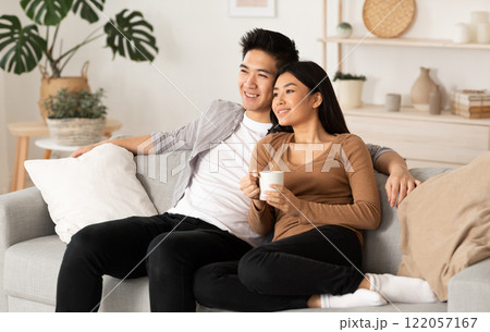 Home Weekend. Lovely filipino couple watching film resting on a couch at home, copy space 122057167