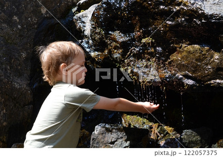 A little boy catches drops of water A little boy catches drops of water 122057375