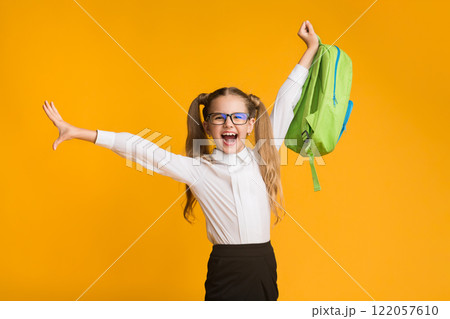 Happy Schoolgirl Enjoying School Break Playing With Backpack On Yellow Background. Free Space 122057610