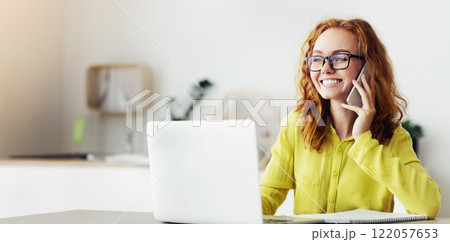 Home Office. Curly Red-Haired Woman In Glasses Talking On Mobile Phone Working Remotely On Laptop 122057653