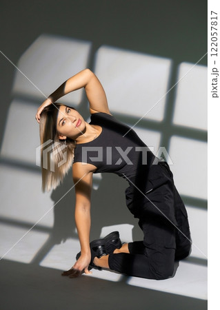 Dancer posing on floor with window shadow projections 122057817