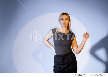 Young dancer performing modern dance illuminated by spotlight in studio 122057825