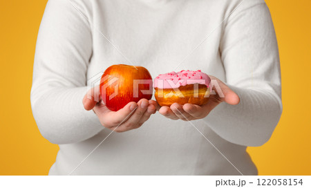 Difficult Choice. Unrecognizable Overweight Girl Holding Donut And Apple In Hands, Comparing Healthy And Unhealthy Food, Selective Focus, Crop 122058154