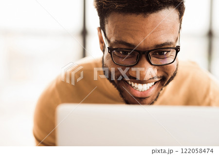 Happy African Businessman Making Video Call To Family Using Laptop During Rest Break At Work, Close-Up Happy African Businessman Making Video Call To Family Using Laptop During Rest Break At Work, Close-Up 122058474