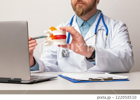 Anatomical lumbar disc herniation model in doctor hand while consultation in medical clinic. Intervertebral hernia treatment 122058510