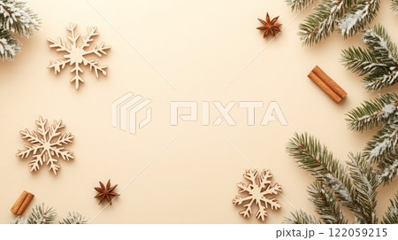 Wooden snowflakes, cinnamon sticks, and star anise are scattered on a beige background. 122059215