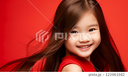 Portrait of smiling asian girl child with long white hair red background. 122061082