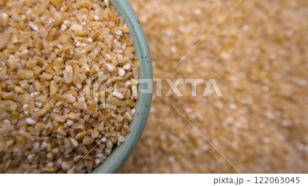 Cracked Broken Crushed Wheat Porridge (Dalia) in a Blue Bowl , Top View Flat Lay Closeup 122063045