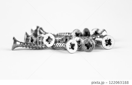 A collection of metal screws scattered on a white background. High quality photo A collection of metal screws scattered on a white background. High quality photo 122063188
