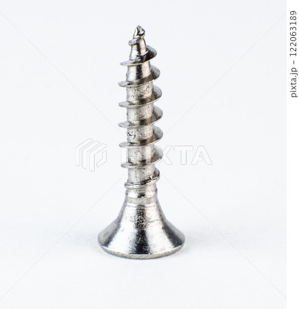 Close-up view of a metallic screw featuring spiral threads. High quality photo 122063189