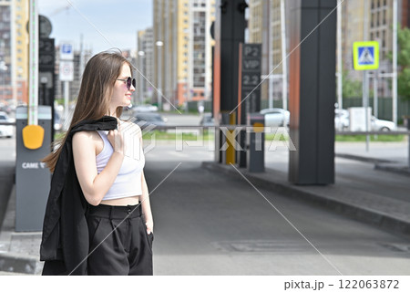 Woman walking near a retractable gate in front of a modern building. Woman walking near a retractable gate in front of a modern building. 122063872