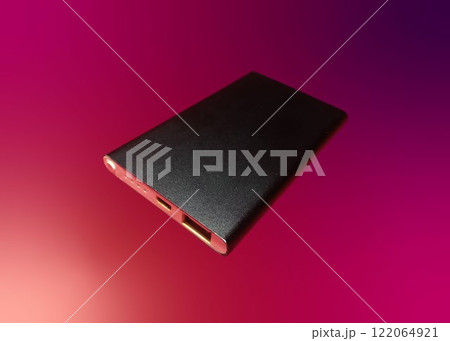 External battery for mobile devices. Power bank for charging mobile devices, isolated on colored background External battery for mobile devices. Power bank for charging mobile devices, isolated on colored background 122064921