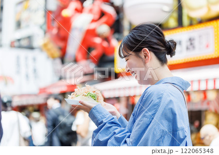 大阪道頓堀で名物のたこ焼きを食べる女性 大阪道頓堀で名物のたこ焼きを食べる女性 122065348