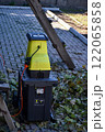 Autumn work in gardening, pruning and crushing branches, wood, in a shredder and mulcher 122065858