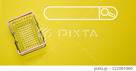 Empty miniature shopping cart on yellow background, top view 122065960