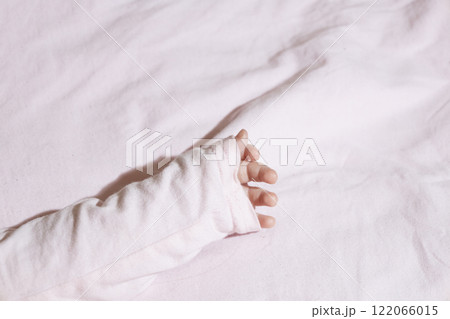 The baby's hand with a little  fingers in pink against white background. Tender fingers of baby girl with copy space 122066015