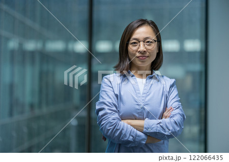 Portrait of confident serious woman inside office, Asian businesswoman looking focused at camera. Office worker working in evening. 122066435