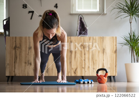 Low nagle front view of a fit young woman holding a plank position 122066522