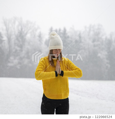 Spiritual young woman practicing mindfulness and gratitude in snowy winter nature Spiritual young woman practicing mindfulness and gratitude in snowy winter nature 122066524
