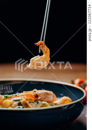Gourmet shrimp pasta served with creamy sauce, elegantly plated with fresh ingredients Gourmet shrimp pasta served with creamy sauce, elegantly plated with fresh ingredients 122067714