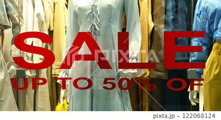 Vibrant display highlights elegant clothing with bold sale signs Vibrant display highlights elegant clothing with bold sale signs 122068124