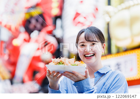 大阪道頓堀で名物のたこ焼きを食べる女性 大阪道頓堀で名物のたこ焼きを食べる女性 122069147