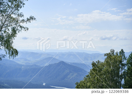 Serene mountain landscape with lush green trees and clear blue sky on a sunny Serene mountain landscape with lush green trees and clear blue sky on a sunny 122069386